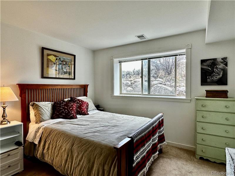 Lower level bedroom with window to rhubarb patch (east)