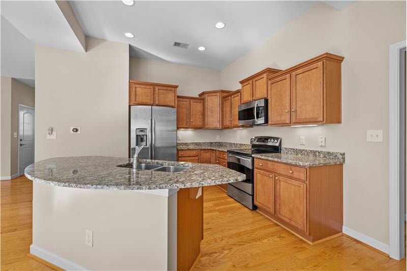 Kitchen features island, granite counters, upgraded cabinets, recessed lighting