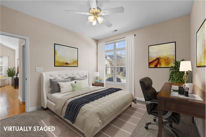 Second bedroom  features neutral carpet and paint; ceiling fan with light