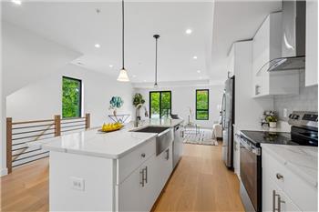 Modern gourmet kitchen featuring a large center island perfect for meal prep and entertaining.