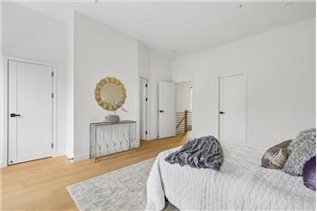 This spacious and light-filled primary bedroom serves as a true private retreat, featuring a s
