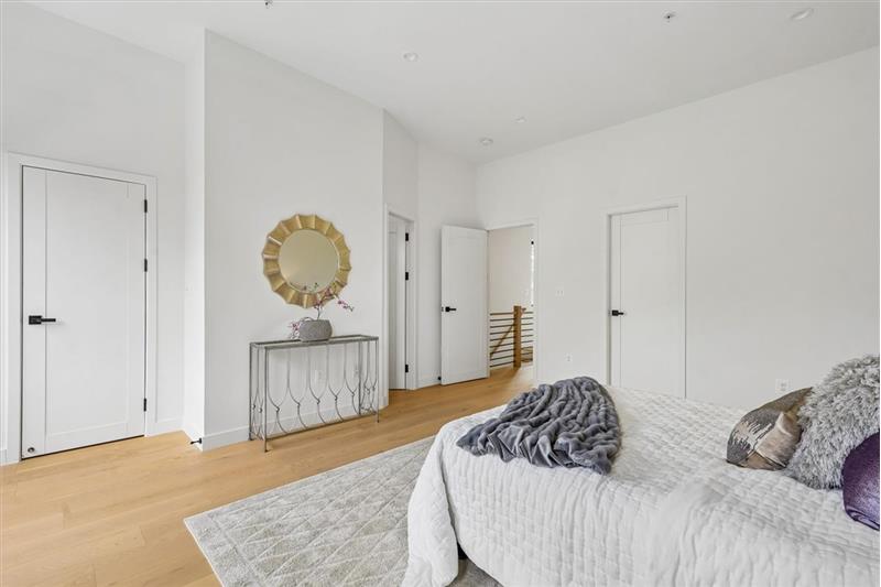 This spacious and light-filled primary bedroom serves as a true private retreat, featuring a s