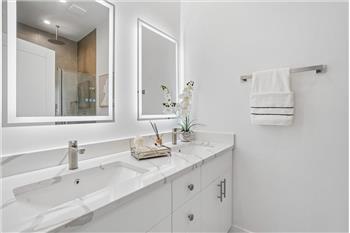 This luxurious and spacious primary bathroom is designed for comfort and convenience, featuring a sleek, modern