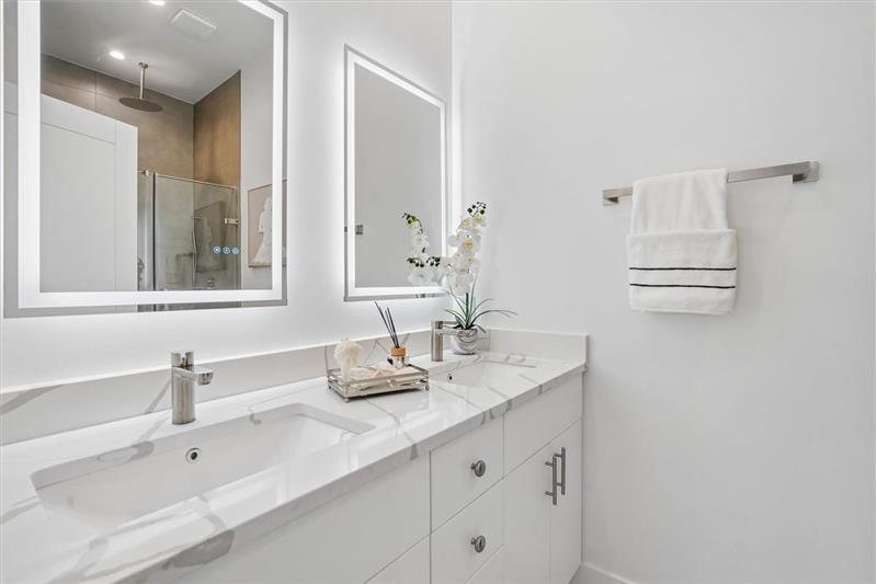 This luxurious and spacious primary bathroom is designed for comfort and convenience, featuring a sleek, modern