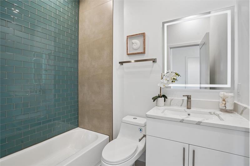 Guest bathroom featuring a modern vanity, tile flooring, and a full-size tub/shower combination.