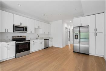Spacious open-concept kitchen featuring modern finishes, perfect for cooking and entertaining. - Rental Unit
