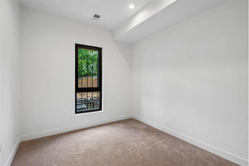 Cozy and spacious bedroom featuring large windows, plenty of natural light, and ample closet space in a prime l