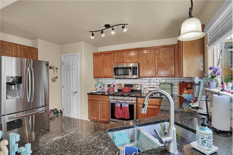 The Kitchen also boasts a walk-in pantry and double under-mount sink with a pendant light