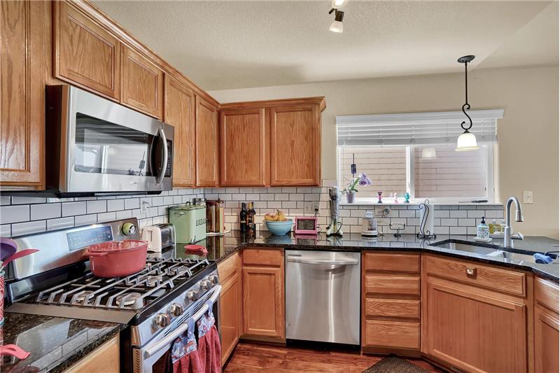 Stainless steel appliances include a gas range oven, built-in microwave, dishwasher, & French door refrigerator