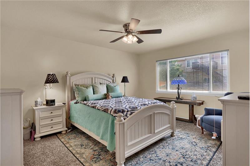 The upper-level Master Bedroom offers a neutral carpet, a lighted ceiling fan, a walk-in closet, & an attached Full Bathroom