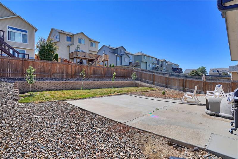 The low maintenance, xeriscaped lot has a fenced backyard, custom retaining wall, and an expanded patio