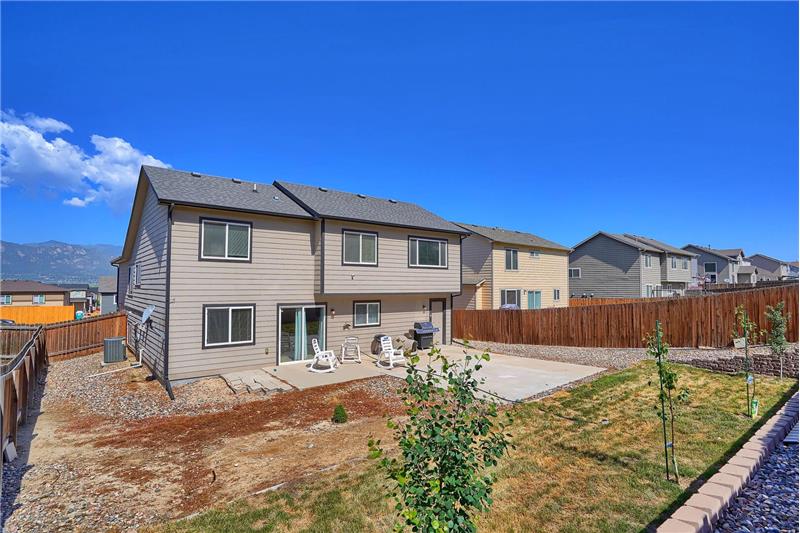 View of the rear of the home and fenced backyard