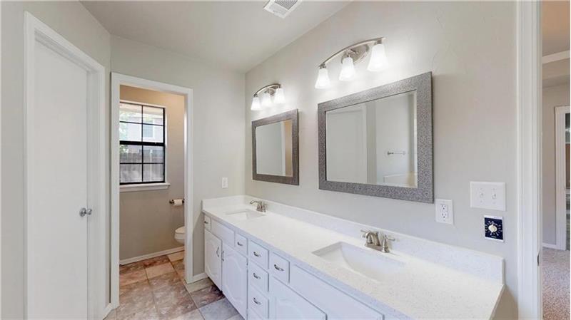 Nicely appointed master bathroom with dual vanities, new sinks, faucets, lighting, mirrors.