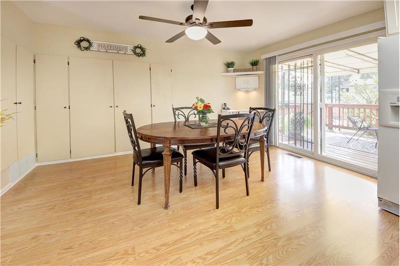 Dining with wood laminate flooring, plentiful storage, and ceiling fan