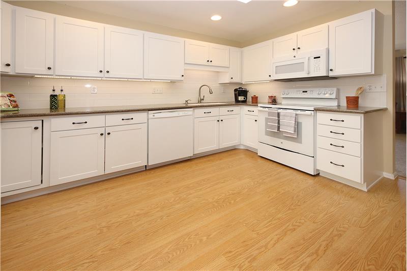 Kitchen with upgraded cabinets with lazy Susan, roll-out shelving, soft close drawers, and under cabinet lighting.
