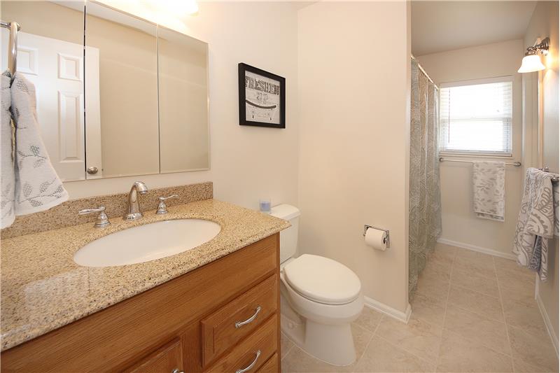 Full bath on main level with tile floors and nicely tiled bath surround