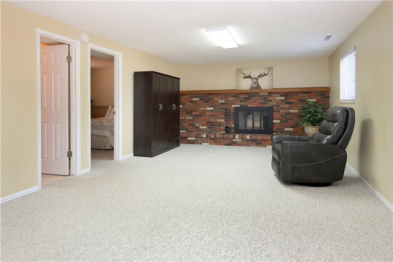 Spacious rec room in lower level with a fireplace