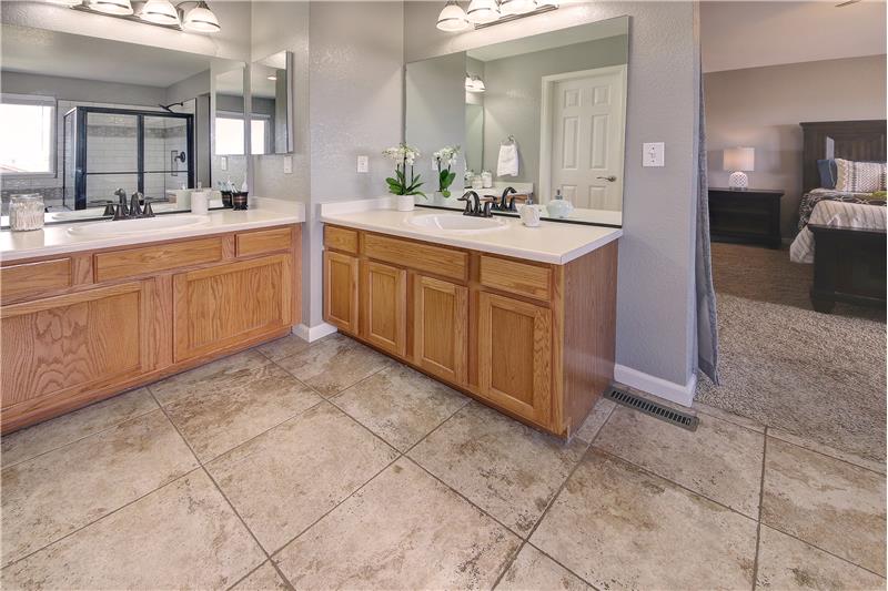 The Master Bathroom Features Tile Floors and Dual Sink Vanities