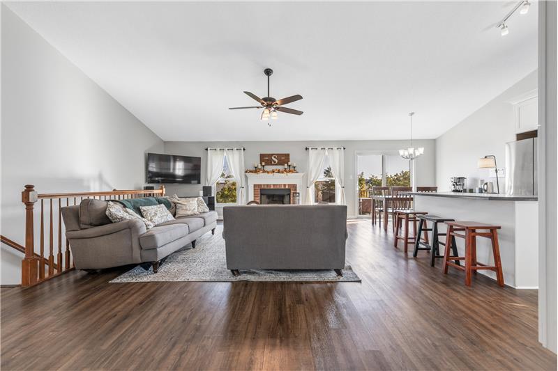 Great room has vaulted ceiling and ceiling fan, vinyl plank flooring.