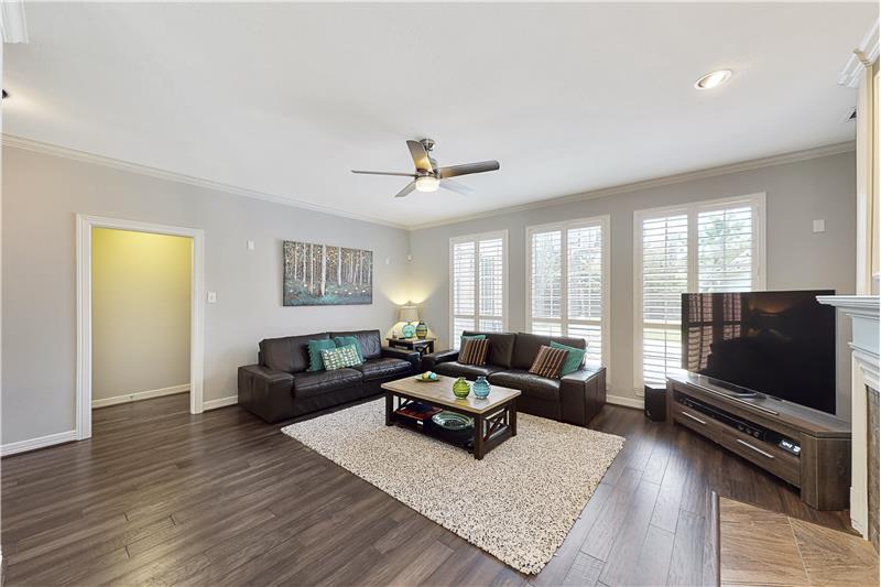The spacious family room offers plenty of room for entertaining and plantation shutters on the windows.