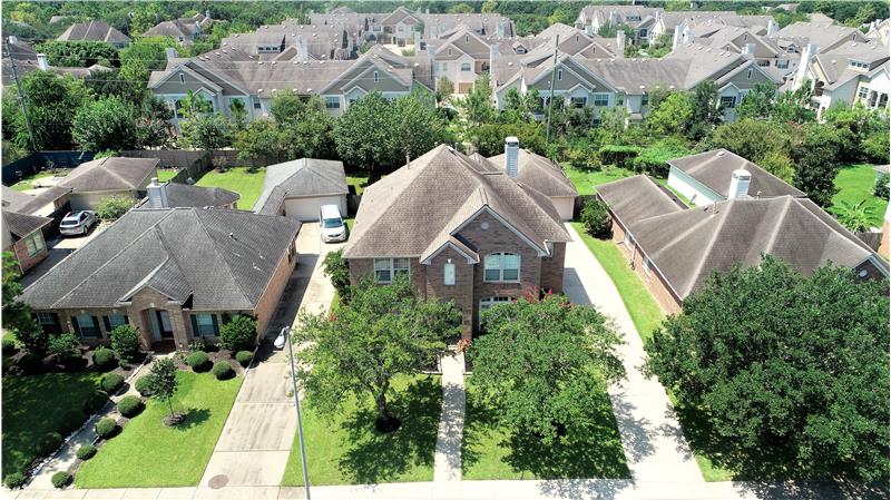 Aerial front view of home with mature trees.