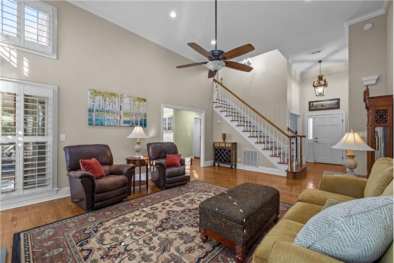 Great room with hardwood floors, crown molding, recessed lights, ceiling fan with light, custom wood plantation shutters.