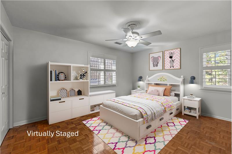 One of three bedrooms on home's second floor featuring parquet floors, ceiling fan with light, double closet, neutral decor.