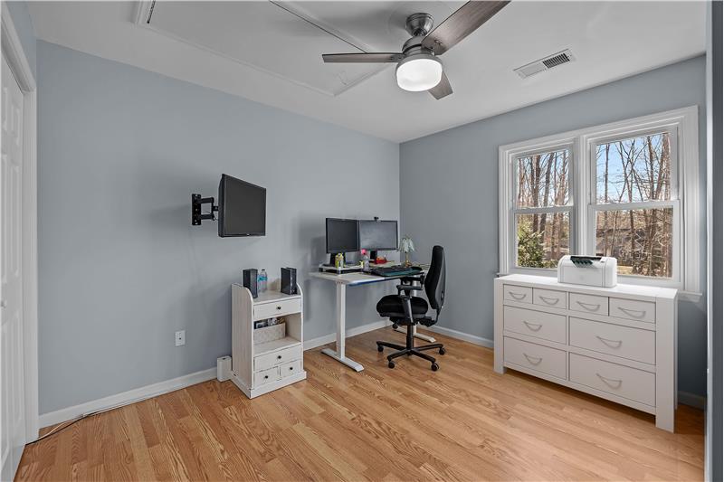 Currently used as a home office, one of three bedrooms on home's second floor featuring ceiling fan with light, neutral decor.