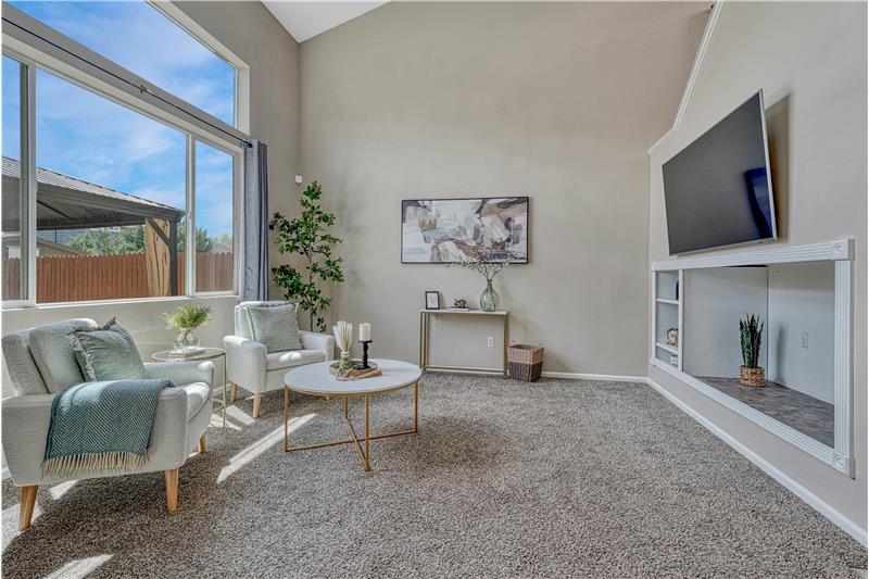 Bright living room with ceiling fan and vaulted ceilings
