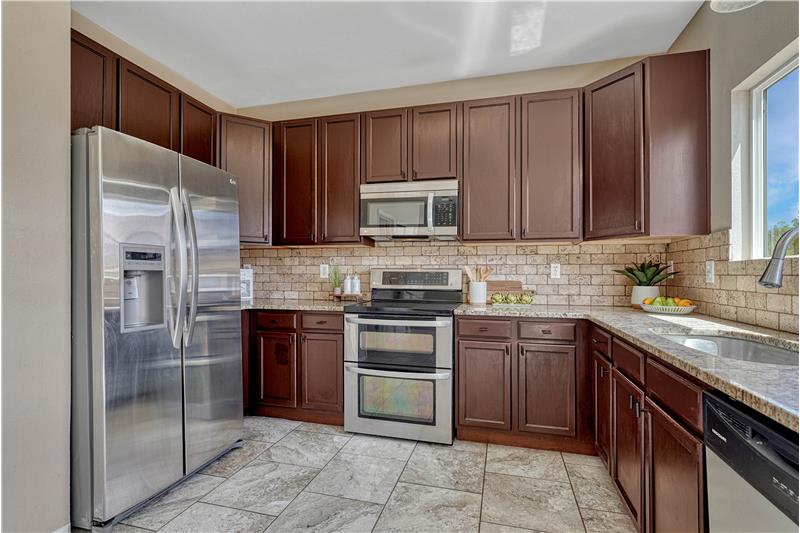 Granite counters, tile backsplash, and a gas range double oven