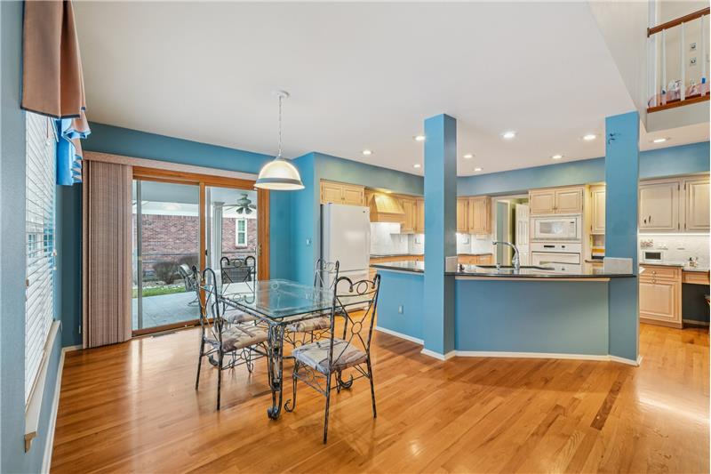 Large eating area next to kitchen with covered patio beyond