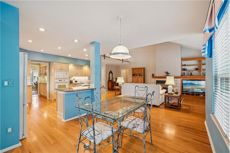 Reverse view of eating area with kitchen and family room beyond