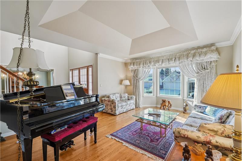 Formal living room with cove ceiling and bay window