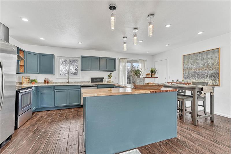 Updated Kitchen with Painted Cabinets, New Countertops, Pendant Lights, and SS Appliances