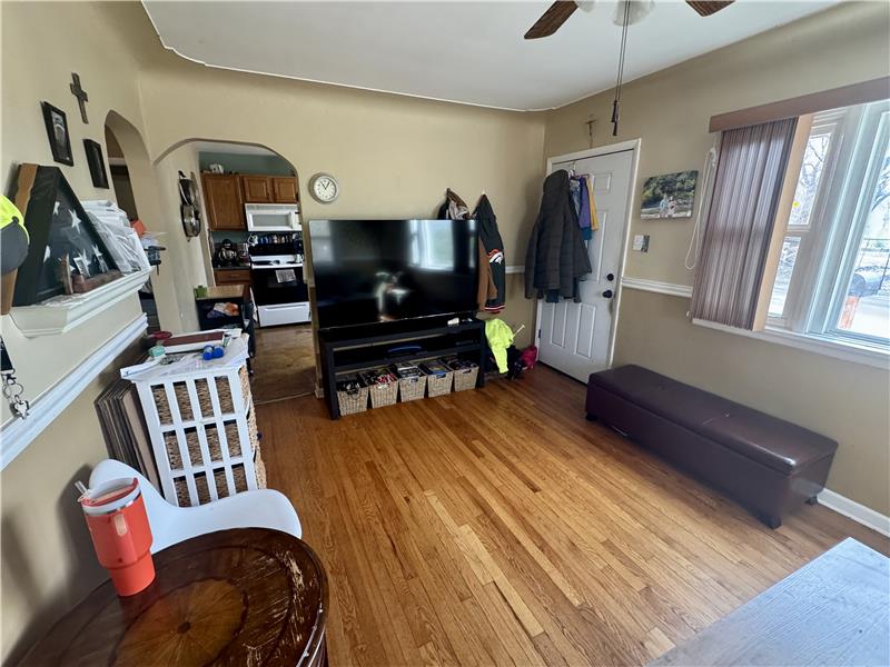 Reverse view of living room, showing kitchen at left and entry at right