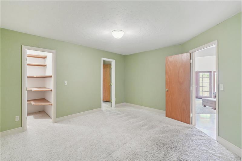 Office. Left to right: doors to walk-in closet, ensuite half bath and living room/dining room