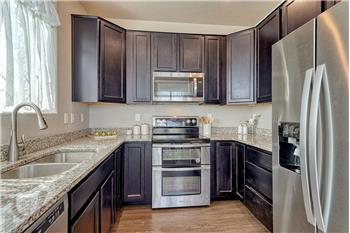 The stylish Kitchen offers dark wood cabinets with granite countertops, and stainless steel appliances.