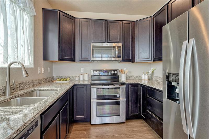The stylish Kitchen offers dark wood cabinets with granite countertops, and stainless steel appliances.