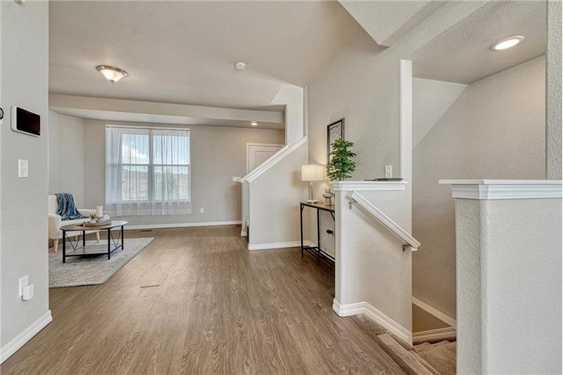 View into the formal Living Room from the Dining Area with stairs to the garage.