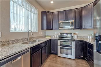 The Kitchen features dark wood cabinetry, granite countertops, and stainless steel appliances.