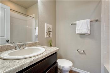 Upper Level Full Bathroom with vanity, mirror, and tiled tub/shower.