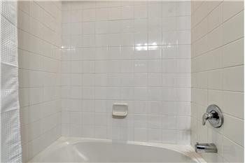 Tiled tub/shower in the upper level hall bathroom.