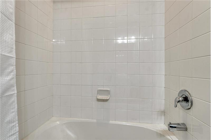Tiled tub/shower in the upper level hall bathroom.
