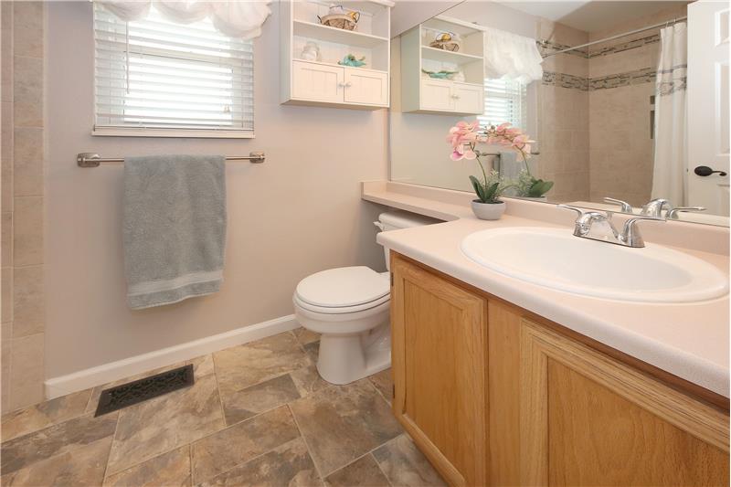 The Master Bathroom includes a tile-look vinyl floor, a vanity, medicine cabinet, window cabinet, and tiled tub/shower