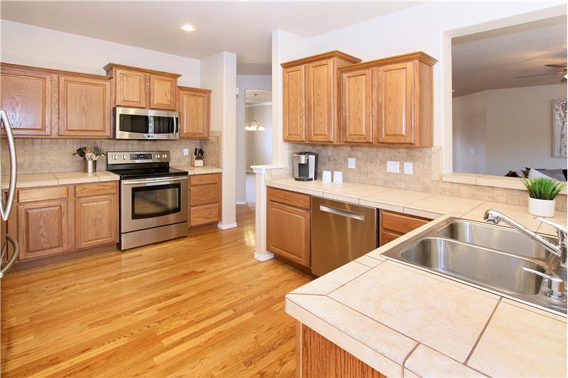 Kitchen with stainless steel appliances, recessed lighting, and tile counters and backsplash