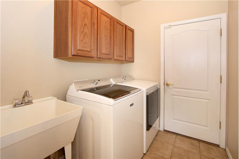 Laundry space with cabinets and utility sink