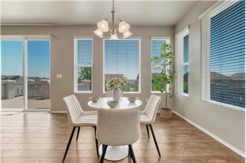 Dining Area with light fixture and wall of windows that bring in lots of natural sunlight.