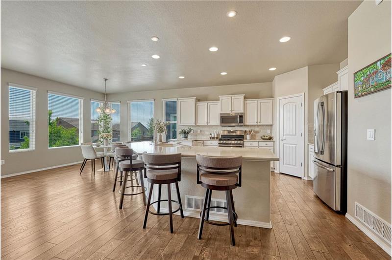 Upgraded island kitchen and dining area with wall of windows and remarkable views.
