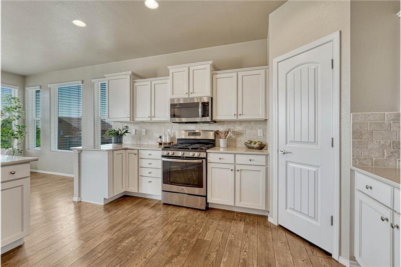 Kitchen pantry and view of the gas range oven and built-in microwave oven.
