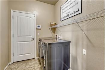 The Laundry Room has garage access and features tile flooring, a built in shelf and washer and dryer that stay.